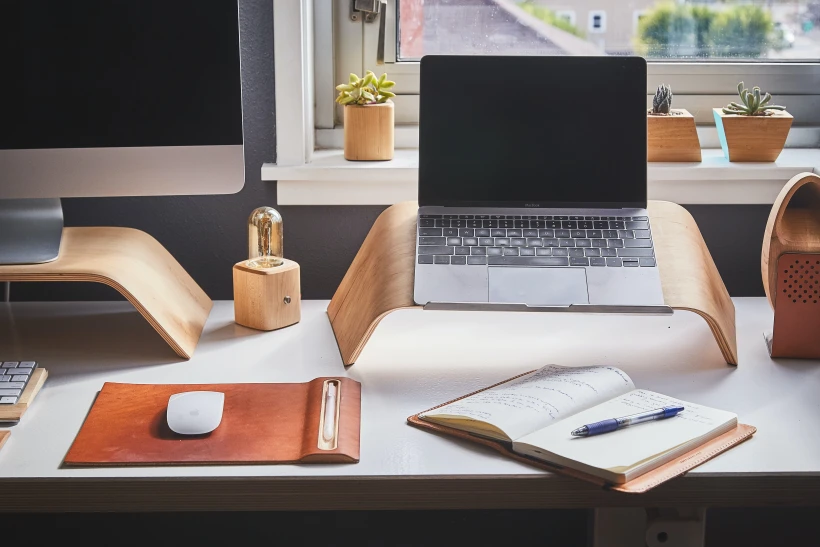 laptop na ergonomicznej drewnianej podstawce w domowym biurze